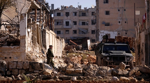 Chiến sự Syria: Một binh sĩ Nga hôm 4/12 bước tới xe quân sự tại khu vực dân cư Hanono do chính phủ kiểm soát tại Aleppo. Ảnh: Reuters 