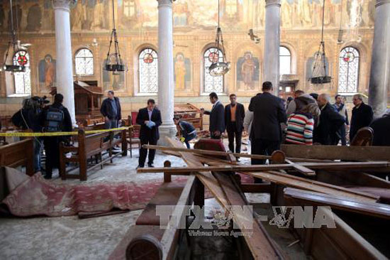  Khủng bố IS: Nhân viên an ninh và người dân điều tra tại hiện trường nhà thờ Công giáo Coptic ở quận Abbasiya sau vụ đánh bom. Ảnh: EPA/TTXVN