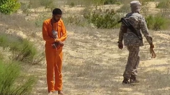  Khủng bố IS: Một phiến quân đeo bom lên tù nhân mặc áo cam, nghi là quân nhân Ai Cập, rồi quay lưng bỏ đi