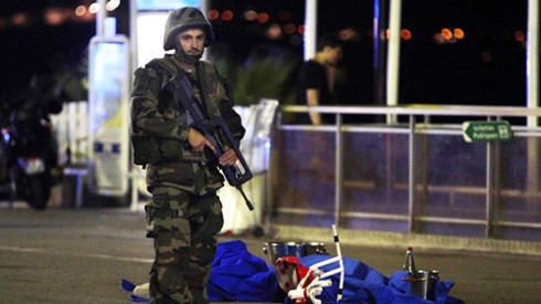 Khủng bố IS: Một binh sĩ Pháp đứng cạnh thi thể một nạn nhân tại hiện trường vụ tấn công khủng bố ở thành phố Nice. Ảnh: AFP