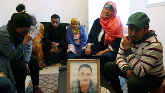 Khủng bố IS: Gia đình nghi phạm vụ khủng bố ở Đức bên ngồi quanh bức chân dung của hắn tại Tunisia. Ảnh: EPA 