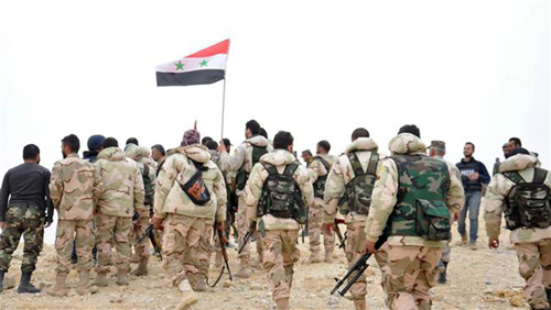 Chiến sự Syria: Binh sĩ Syria tập trung quanh lá quốc kỳ. Ảnh: SANA/AP