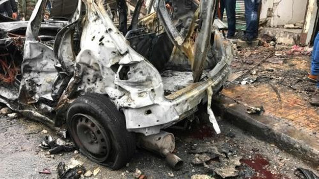  Chiếc xe bị phá hủy tại hiện trường vụ đánh bom liều chết ở Syria. Ảnh: AFP