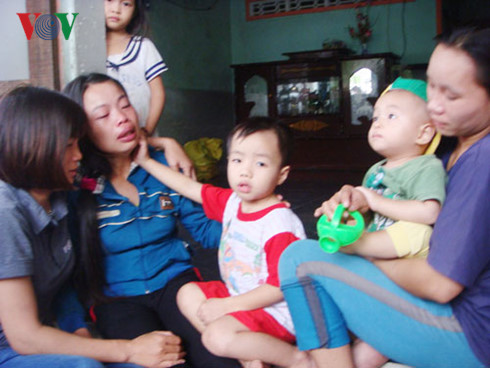  Chị Phạm Thị Lắng cùng 2 con của nạn nhân Lê Thành khóc ngất khi nghe tin chồng, cha tử nạn dưới hầm nước mắm. Ảnh: VOV