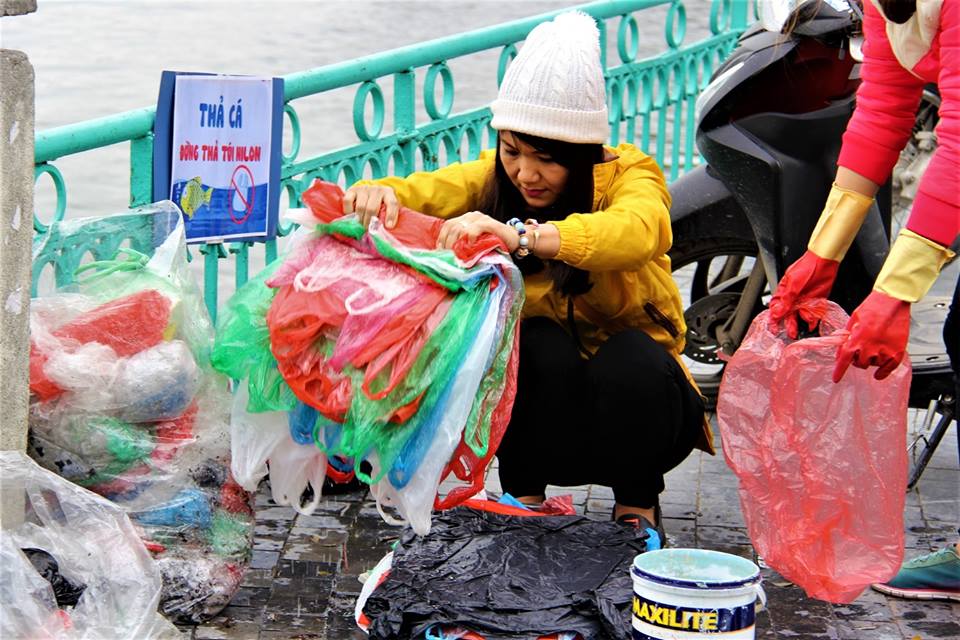  Các tình nguyện viên thu gom túi nilon sau khi người dân thả cá