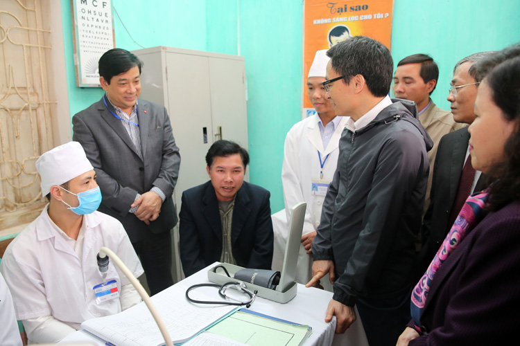 Phó Thủ tướng Vũ Đức Đam trò chuyện với một người dân khám bệnh tại trạm y tế xã Minh Đức, huyện Việt Yên, tỉnh Bắc Giang. Ảnh: VGP