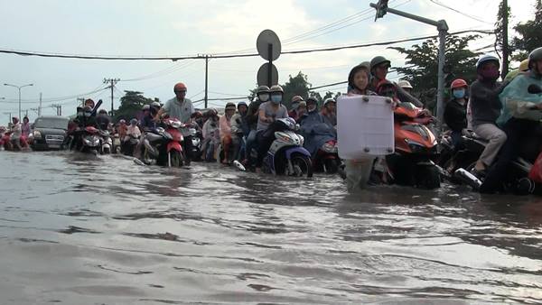 Báo VietNamNet đưa tin, đoạn gần chân cầu Bình Điền nước ngập hơn nửa mét khiến hàng loạt phương tiện chết máy. Nhiều người cho biết, mặt đường ngập lênh láng nước nên họ bị té ngã do sụp ổ voi, ổ gà. Ảnh: VietNamNet  