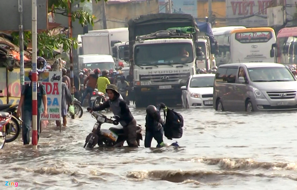 Theo báo Zing.vn, các ôtô chạy ngang, sóng nước đánh mạnh khiến nhiều xe máy chao đảo té ngã dưới nước. Nhiều đồ đạc, túi xách của người dân bị rơi xuống nước hư hại. Ảnh: Zing.vn 