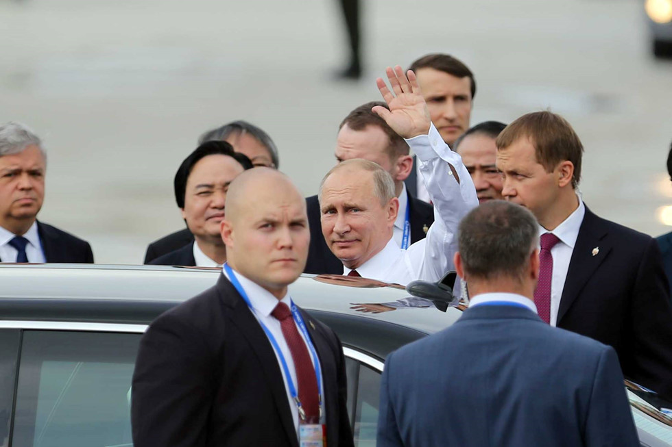Sau khi bắt tay các quan chức Việt Nam ra đón đoàn, Tổng thống V. Putin bước lên chiếc siêu xe Mercedes S-600 luôn được ông Putin sử dụng trong các chuyến công du nước ngoài, không quên vẫy tay chào những người có mặt trên sân bay. Ảnh: Thanh niên   