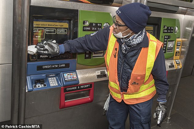 Nhân viên vệ sinh bề mặt máy ATM tại New York, Mỹ.
