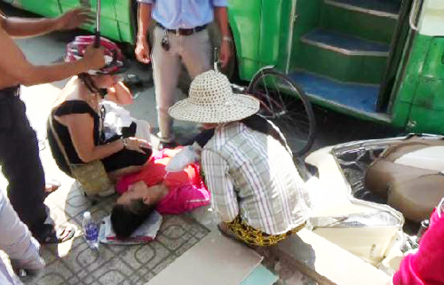 Người phụ nữ bị kẹt dưới bánh xe buýt được mọi người kéo ra ngoài chờ chuyển đi cấp cứu