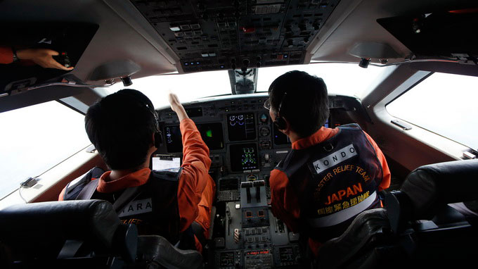 Máy bay MH370 chưa được tìm thấy. Trong ảnh là phi công cứu hộ Nhật quan sát mặt biển từ buồng lái máy bay tìm kiếm - Ảnh: Reuters 