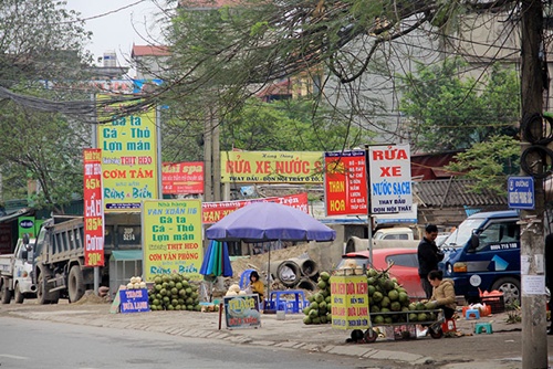Vỉa hè ở đường Nguyễn Phong Sắc kéo dài giờ đã bị lấn chiếm để mở quán nước và treo các biển quảng cáo 