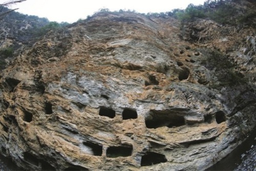 Cà nhà khảo cổ học mới phát hiện những cỗ huyền quan nằm cheo leo trên vách đá ở Hang Tiên tại Trung Quốc. Ảnh: ECN