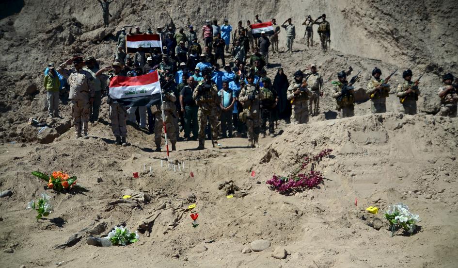 Binh sĩ Iraq thực hiện nghi thức chào bên cạnh ngôi mộ tập thể những binh lính Shi'ite của khủng bố IS ở trại Speicher 