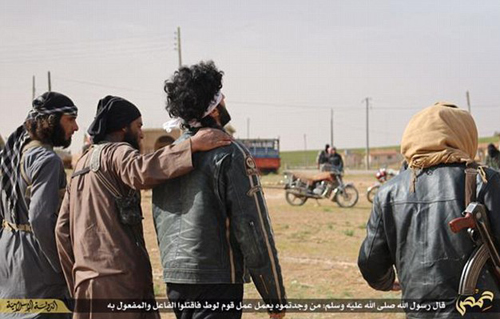 Phiến quân khủng bố IS khoác vai và ‘an ủi’ nạn nhân bị ném đá (thứ ba từ trái sang)