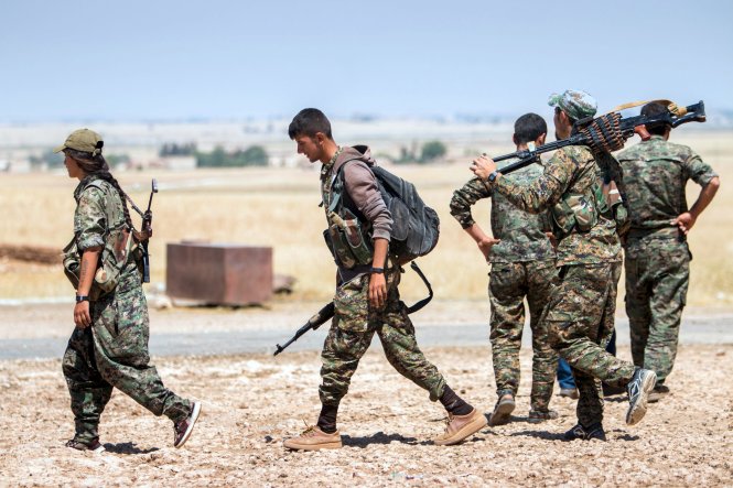 Các binh sĩ người Kurd di chuyển bên ngoài thị trấn Tal Abyad, nơi từng là trung tâm tài chính và hậu cần của khủng bố IS