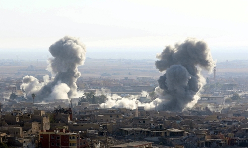 Khói bốc lên sau một đợt không kích của liên minh quốc tế ở thị trấn Sinjar, Iraq