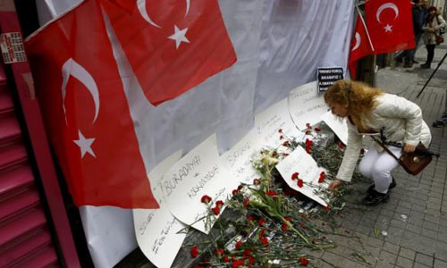 Một phụ nữ đặt hoa tưởng niệm các nạn nhân thiệt mạng trong vụ đánh bom hôm qua
