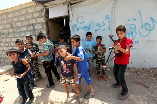 Trẻ em Iraq chơi cùng những khẩu súng đồ chơi phía ngoài một trại tị nạn ở ngoại ô thành phố Arbil hôm 17/7