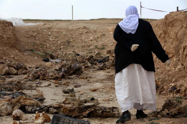 Một người dân Yazidi đang tìm kiếm thi thể người nhà trong số những nạn nhân bị IS giết hại 