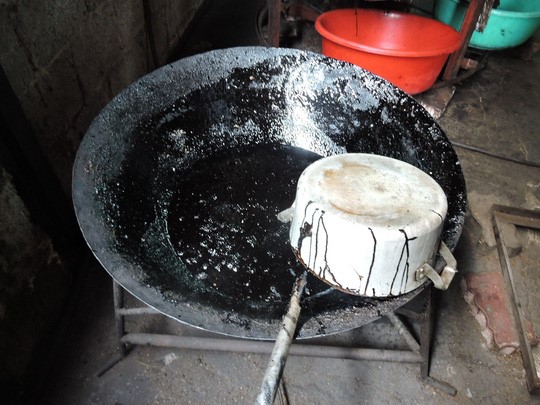 Chảo dùng để nấu caramen đen đặc, cháy khét tại cơ sở rang cà phê bẩn