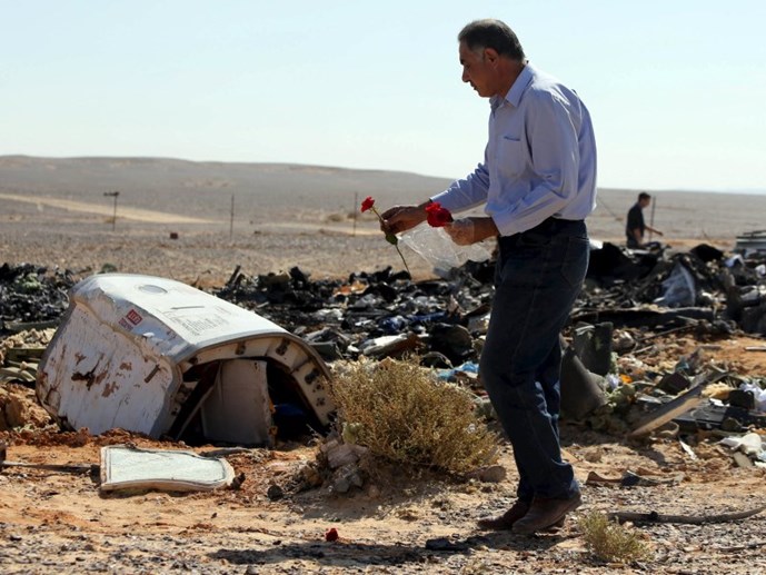 Một người đàn ông Ai Cập đặt hoa tưởng niệm tại hiện trường vụ máy bay Nga rơi ở bán đảo Sinai