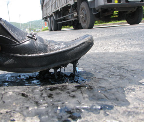 Trong thời tiết nắng nóng mùa hè, nhựa đường dính chặt vào đế giày khiến giao thông bị ảnh hưởng