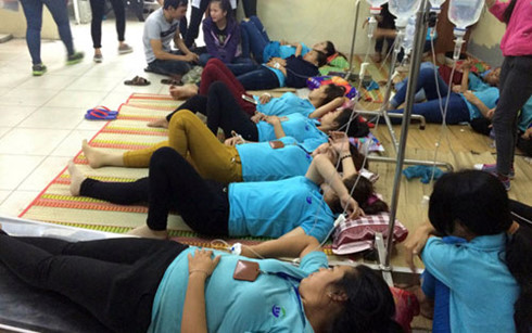 Các công nhân bị ngộ độc thức ăn được truyền dịch tại phòng khám Tân Quy