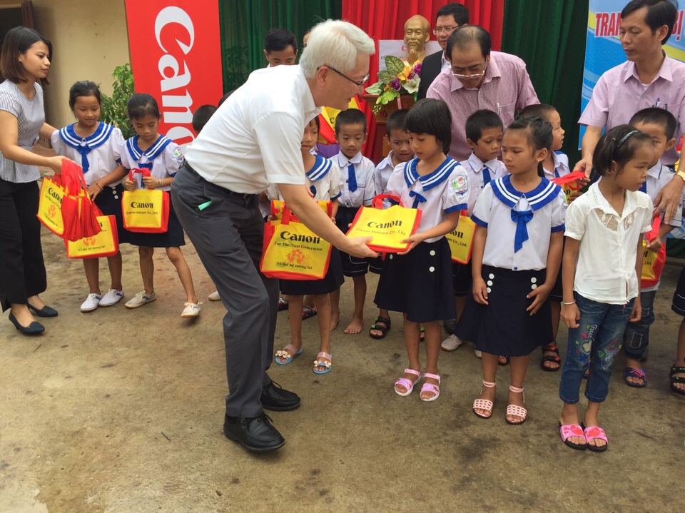 Lãnh đạo Công ty Canon Việt Namt ặng quà cho các em học sinh