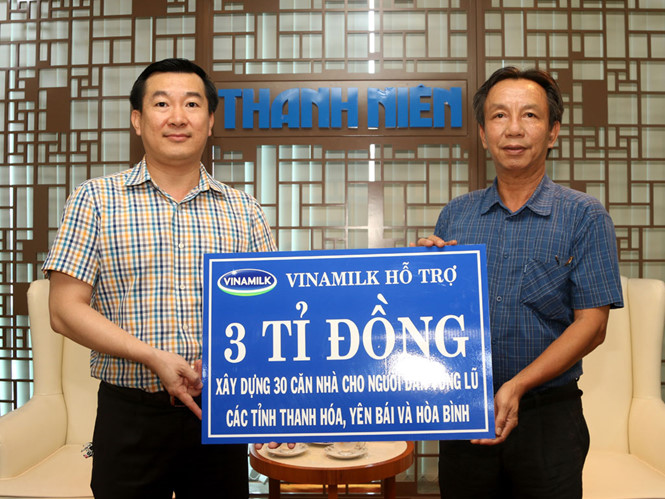 Ông Đỗ Thanh Tuấn (trái) trao biểu trưng 3 tỉ đồng cho nhà báo Nguyễn Quang Thông