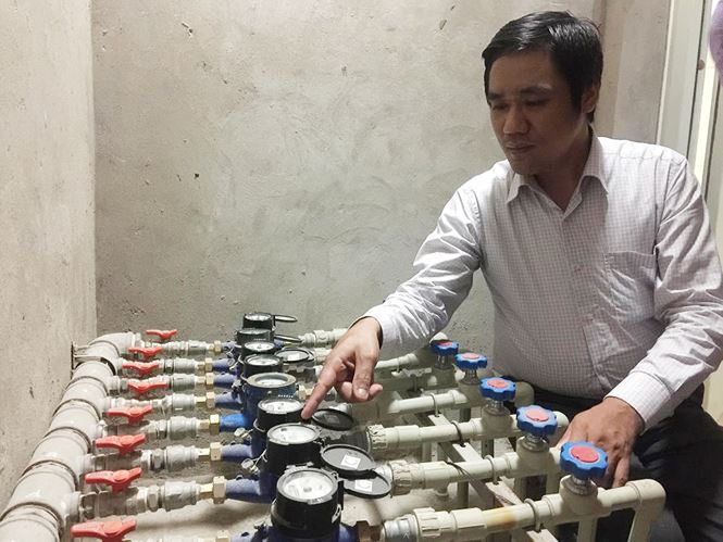 Ông Điền đang kiểm tra các đồng hồ nước lắp cho các hộ gia đình. Ảnh: ST