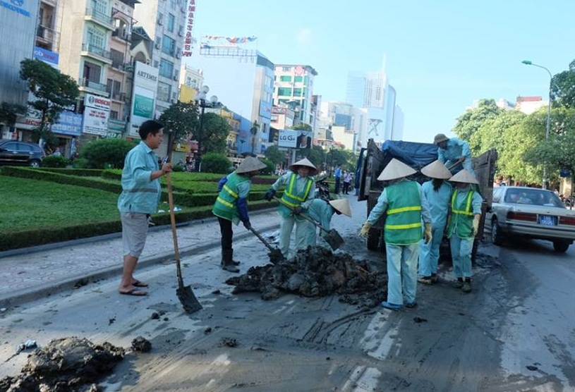 Công nhân môi trường dọn dẹp đống bùn đất trên đường Nguyễn Chí Thanh