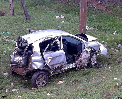 Chiếc xe ô tô bị biến dạng sau cú va chạm với xe máy, cột mốc và biển báo trong vụ tai nạn giao thông đáng tiếc ở Hà Tĩnh