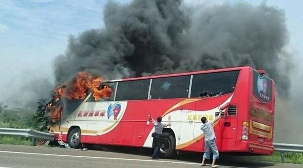 Chiếc xe buýt chở du khách Trung Quốc bốc cháy sau khi đâm vào dải rào chắn vệ đường cao tốc. Ảnh: Tân Hoa Xã