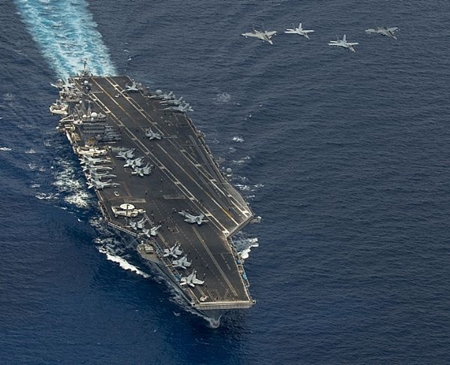 Hai chiếc F/A-18 Super Hornet và hai chiếc Mig-29 của Không quân Hoàng gia Malaysia bay thành đội hình trên tàu sân bay USS Carl Vinson