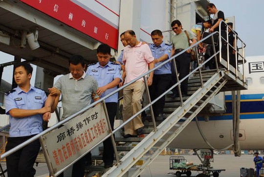 Hai nghi phạm tham nhũng trung quốc bị áp giải từ Campuchia hồi tháng 8/2014. Ảnh China Daily 