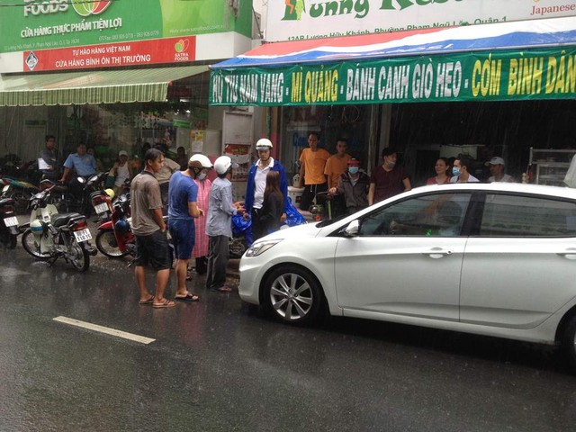Anh Phương (mặc áo sơ mi trắng) đứng giữa mưa gió bắt tài xế ô tô gây tai nạn giao thông phải xuống xe xin lỗi
