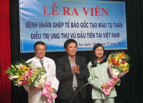 Chị Đinh Thị Liễu (bên phải) và PGS.TS Nguyễn Trung Chính (cầm hoa bên trái) trong buổi lễ ra viện