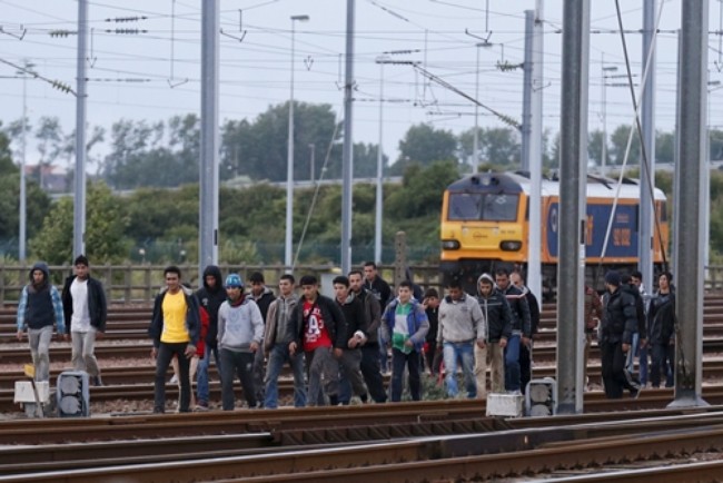 Người nhập cư đi dọc theo đường tàu, tìm cách vào đường hầm eo biển Manche ở khu Frethun, gần thị trấn Calais, Pháp, ngày 29/7