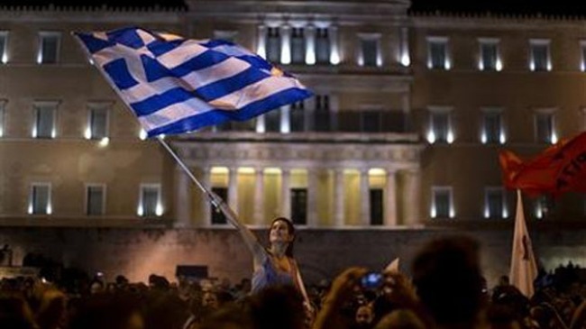 Một người ủng hộ bỏ phiếu 'Không' trong cuộc trưng cầu dân ý vẫy cờ Hy Lạp trước trụ sở Quốc hội nước này, tại Thủ đô Athens