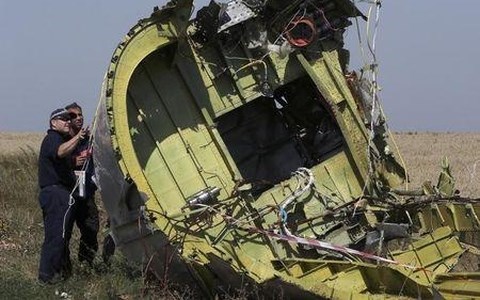 Các nhân viên điều tra xem xét hiện trường máy bay MH17 