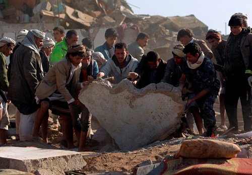 Người dân Yemen và lực lượng an ninh tìm kiếm người sống sót sau khi một tòa nhà bị phá hủy vì không kích. Ảnh AFP