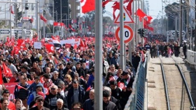 Theo tin tin tức mới nhất, đoàn tuần hành vẫy cờ Tunisia và mang theo biểu ngữ cùng nhau chống lại chủ nghĩa khủng bố