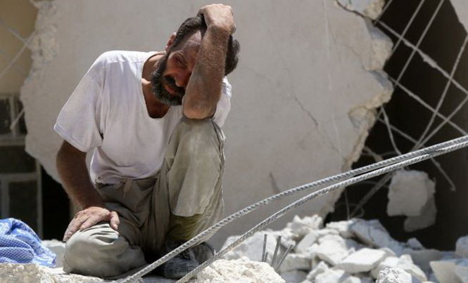 Một người đàn ông suy sụp giữa đống đổ nát của một tòa nhà bị không kích ở Syria, theo tình hình chiến sự Syria mới cập nhật 