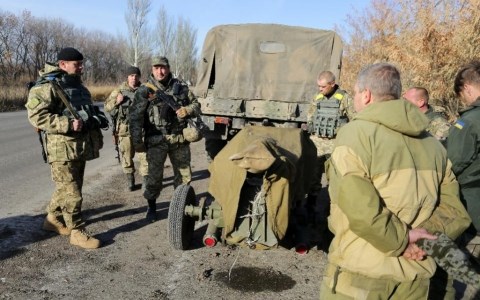 Binh sĩ Ukraine đứng gần một khẩu pháo chuẩn bị được rút ra khỏi miền Đông