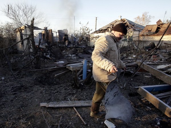Người dân Ukraine thu dọn đống đổ nát của một ngôi nhà bị phá hủy sau vụ cháy nổ