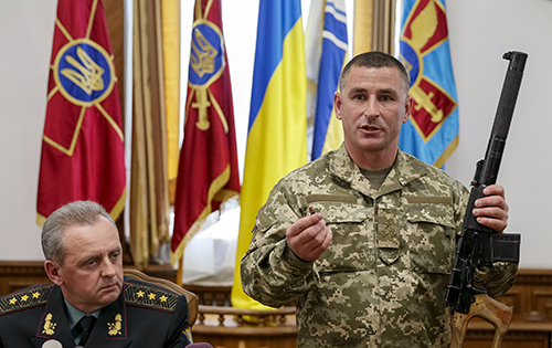 Một chỉ huy Ukraine cầm khẩu súng trường mà ông tuyên bố là tịch thu từ hai nghi phạm binh lính Nga