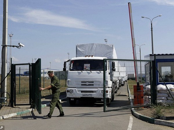 Một binh sỹ mở cửa biên giới để các xe tải chở hàng viện trợ vào Ukraine