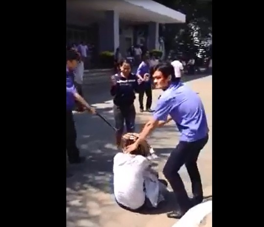 nhiều nhân viên bảo vệ Bệnh viện Đa khoa Quảng Ngãi cầm gậy vây lại đấm đá một thanh niên đang nằm dưới đất